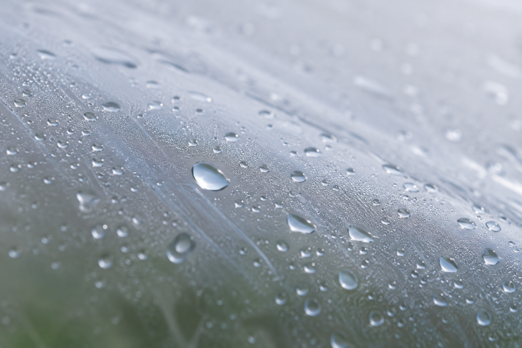 Anti-drip greenhouse film surface with water droplets designed to reduce condensation on crops
